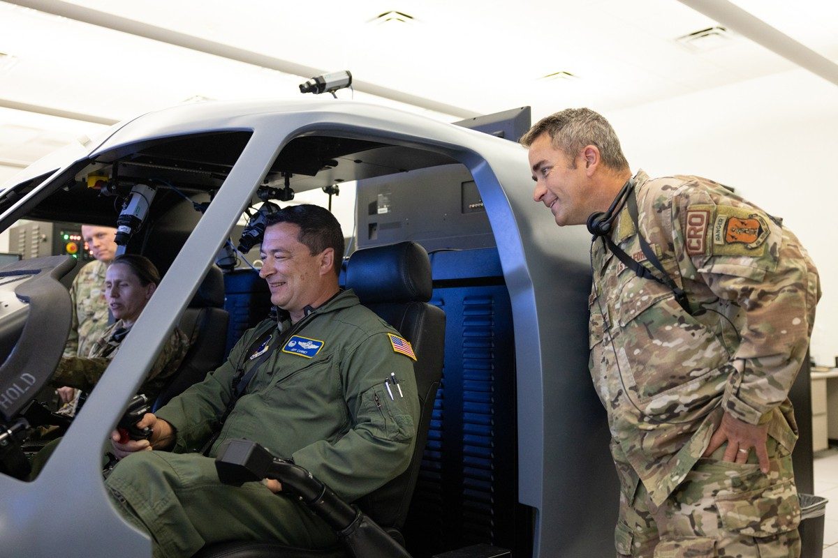 U.S. Air Force Major General Denise Donnell, Assistant Adjutant General and Commander of the New York Air National Guard, and Colonel Jeff Cannet, 106th Rescue Wing Operations Group Commander, sit in the cockpit of an HH-60W flight simulator developed by Lockheed Martin. Photo courtesy Sikorsky, a Lockheed Martin company.